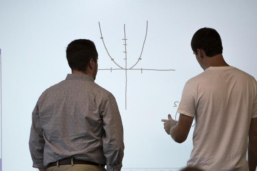 Two people look at a graph.