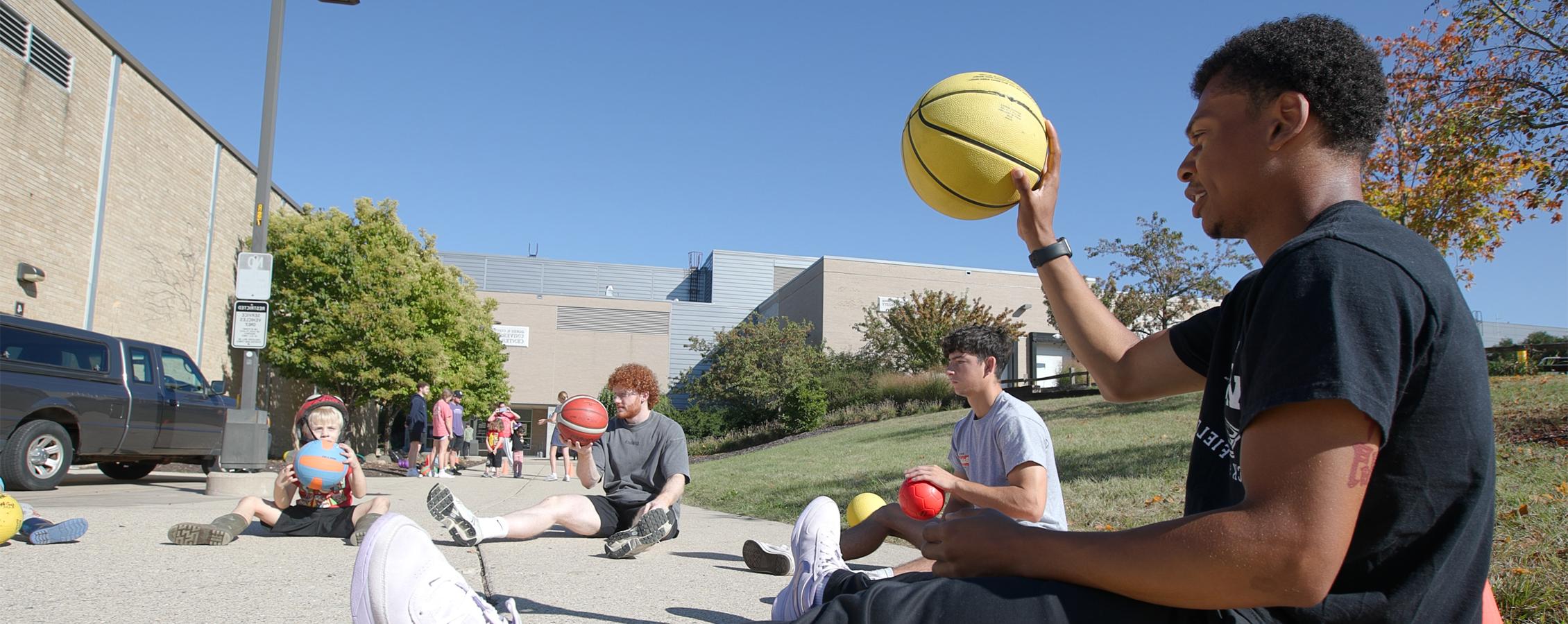 One person guides another person through air-filled gym equipment.